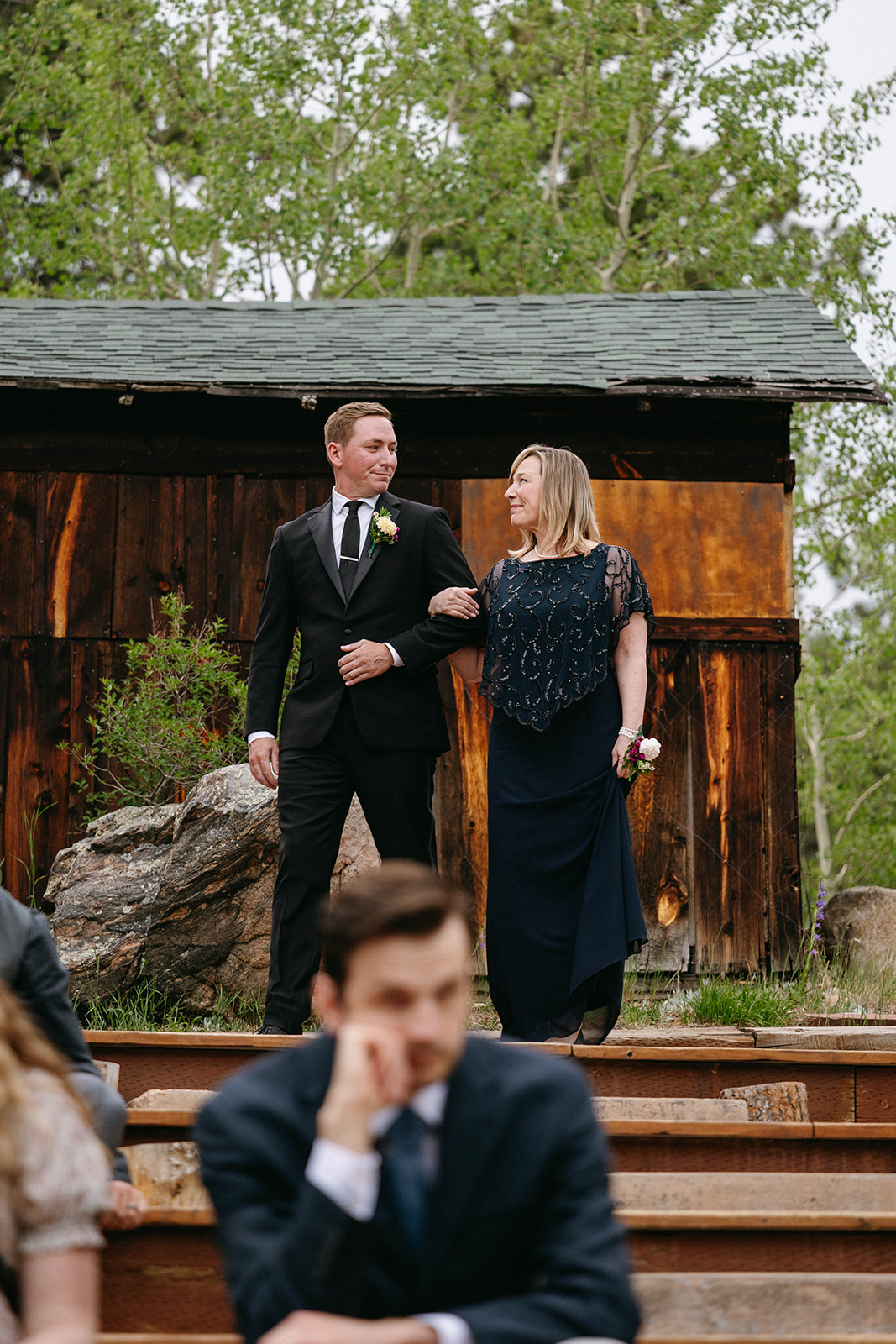 Jason and Amy kissing on the rocks framed by aspen trees